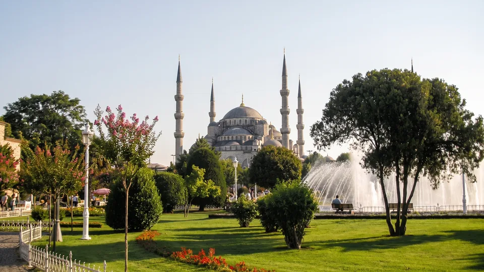 Blue Mosque exterior behind trees and a fountain in Sultanahmet Park