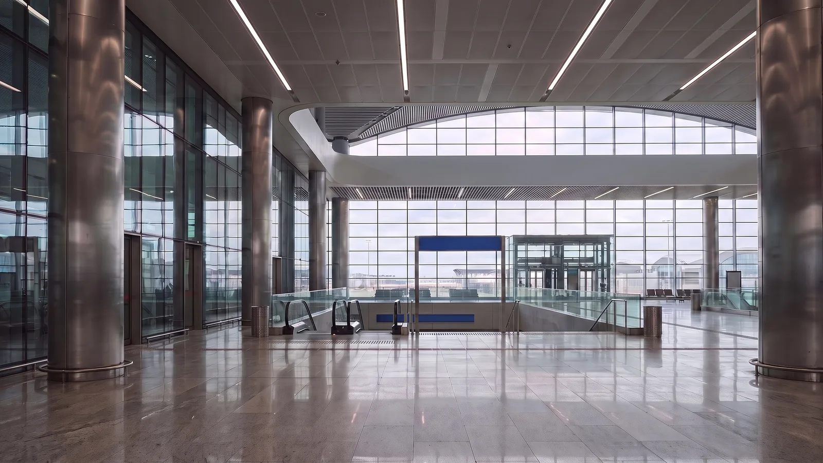 Empty modern airport terminal interior with escalators and glass walls